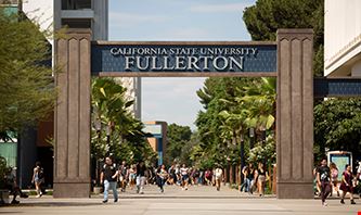 CSU Fullerton's Main Gate with the university name etched and students walking around.