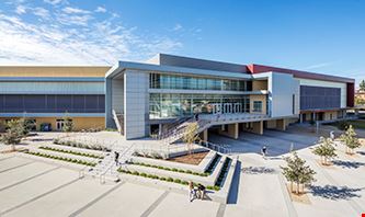 Wide angle of San Bernardino Valley College buildings with two students sitting at a bench.